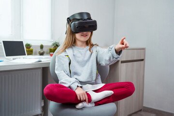 Wall Mural - schoolgirl is using virtual reality simulator headset for study. child is wearing virtual reality gl