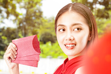 Poster - Asian Chinese woman in a cheongsam dress holding red envelopes