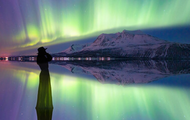 Wall Mural - young girl in dress and black hat walking on the water - northern lights (aurora borealis) in the sk