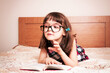© gmstockstudio - Little girl reading a book at home