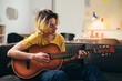 © cherryandbees - teenage boy playing acoustic guitar at home