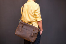 Man With Brown Leather Messenger Bag On Gray Background