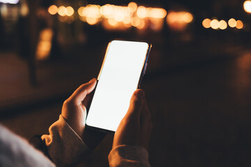 Smartphone with blank display in female hands outdoors