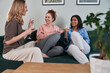 © gpointstudio - Three  female caucasian friends chatting and drinking wine at home