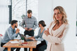 © standret - Woman in white clothes standing in front of her employees. Group of business people that working on the project in the office