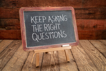 Canvas Print - keep asking the right questions inspirational reminder - white chalk handwriting on a slate blackboard, easel sign against rustic, weathered wood, education, business and science concept