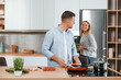 © standret - Preparing dinner. Couple at home on the modern kitchen