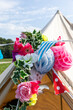 © Image Source RF - Close-up of flowers and paper decorations hanging in front of tent