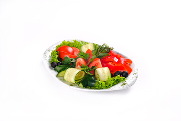 Wall Mural - Delicious vegetable salad of tomatoes and cucumbers with olives on a plate on an isolated background