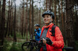 © Halfpoint - Senior couple bikers with e-bikes admiring nature outdoors in forest in autumn day.