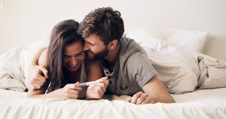 Poster - We're going to make great parents. Shot of a happy young couple taking a pregnancy test at home.