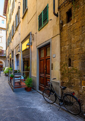Fototapete - View of narrow street with tables of old trattoria in Florence, Tuscany, Italy. Architecture and landmark of Florence. Cityscape of Florence