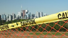 Yellow Caution Tape With Defocused View Of Toronto In The Background. Concept Shot Of The Isolation Caused By The Covid 19 Pandemic.