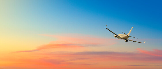 airplane flying above clouds in sunset light