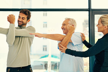 Poster - Helping him get it just right. Shot of two physiotherapists helping their senior patient with his exercises.