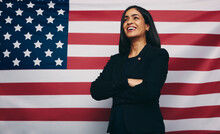 Happy Young Congresswoman Smiling Against An American Flag