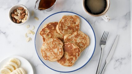 Wall Mural - Serving plate of healthy vegan protein pancakes, top view. Healthy breakfast pancakes with banana, syrup and cup of coffee