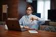 Upset business woman in glasses sit at laptop, showing dislike with thumb down, negative feedback, rejection concept