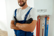© Kostiantyn - Cropped shot of smiling technician installing and setting the new gas boiler for hot water and heating, standing with arms crossed