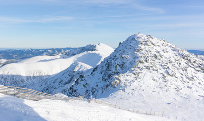 Valley of hilghland mountain winter resort on bright sunny day. Panoramic wide view of downhill slopes