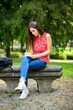 © Minerva Studio - Beautiful female college student reading a book on a bench in a park