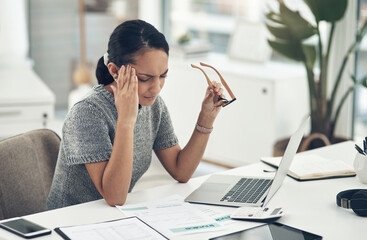 Poster - Overworked and feeling it. Shot of a young businesswoman looking stressed out while working in an office.