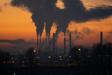 Winter industrial landscape. Coal-fired power station with smoking chimneys against dramatic sunset sky. Air pollution in city. Carbon dioxide CO2 emissions as primary driver of global climate change