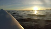 Surfer Paddling On Baltic Sea Waves At Sunrise POV Slow Motion