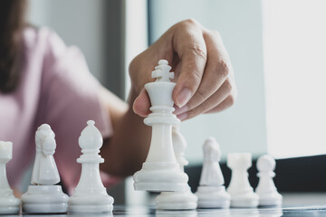 Wall Mural - Hand of businesswoman moving, chess in competition shows leadership, followers, and business success strategies