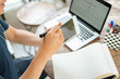 © Pichsakul - Online studying concept the young company man who puts a computer laptop on the wooden table being busy to have the checklist on the book done by writing it down on his technology device