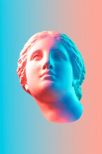 Gypsum Copy Of The Ancient Statue Of Venus De Milo In Pastel Tone For Artists On Pink Blue Background. Plaster Sculpture Of A Woman's Face. Art Modern Poster In Soft Colors. Love, Beauty, Feminism.