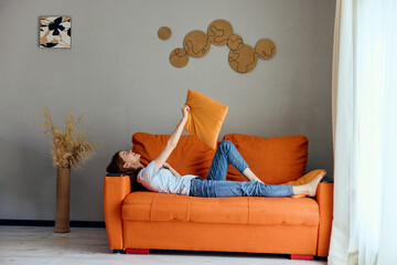 cheerful woman on the orange couch in the rest room posing Lifestyle