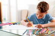 © khmelev - Back to school. Caucasian little schoolboy drawing picture at home. Home schooling