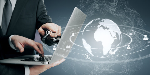 Aufkleber - Close up of businessmen hands holding and pointing at laptop with glowing social globe hologram on blue background. Information, teamwork data and communication concept.