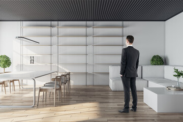 Aufkleber - Businessman standing in modern conference room interior with glass partition, wooden flooring and daylight. Workplace concept.