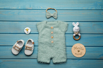 Wall Mural - Flat lay composition with cute baby knitwear for photoshoot on light blue wooden background