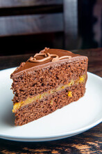 Chocolate Austrian Dessert Sacher With Apricot Jam. One Slice Of Traditional Sacher Cake Served On A White Plate