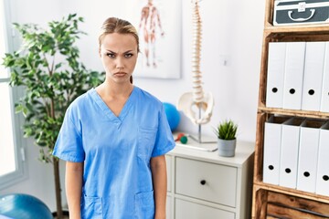 Canvas Print - Young caucasian woman working at pain recovery clinic skeptic and nervous, frowning upset because of problem. negative person.