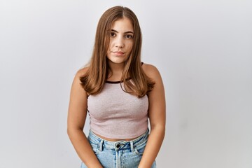 Poster - Young brunette woman standing over isolated background relaxed with serious expression on face. simple and natural looking at the camera.