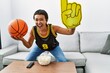 Young hispanic woman smiling confident supporting basketbal game at home