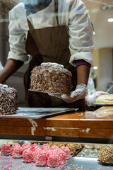 A hands of confectioner-chocolatier during at work. The making of cake 