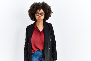 Sticker - African american woman with afro hair wearing business jacket and glasses puffing cheeks with funny face. mouth inflated with air, crazy expression.