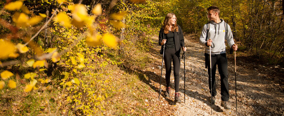 Young couple hikino on a warm autumn afternoon in nature