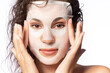 © deniskomarov - Young woman use cloth moisturizing rejuvenation collagen facial sheet mask to nourish face, improve complexion. Beauty spa treatment for glowing healthy skin. Skincare cosmetic selfcare procedure.