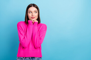 Wall Mural - Photo of shiny shy young lady wear pink pullover arms chin looking empty space smiling isolated blue color background