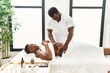 © Krakenimages.com - Young physiotherapist man giving abdominal massage to african american woman at the clinic