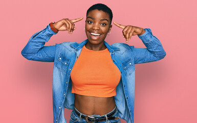 Wall Mural - Young african american woman wearing casual clothes smiling pointing to head with both hands finger, great idea or thought, good memory