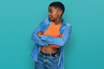 Wall Mural - Young african american woman wearing casual clothes looking to the side with arms crossed convinced and confident