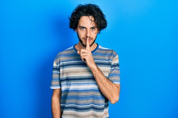 Sticker - Handsome hispanic man wearing casual clothes over pink background asking to be quiet with finger on lips. silence and secret concept.