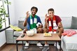 © Krakenimages.com - Young hispanic brothers football hooligans holding ball and megaphone doing ok sign with fingers, smiling friendly gesturing excellent symbol